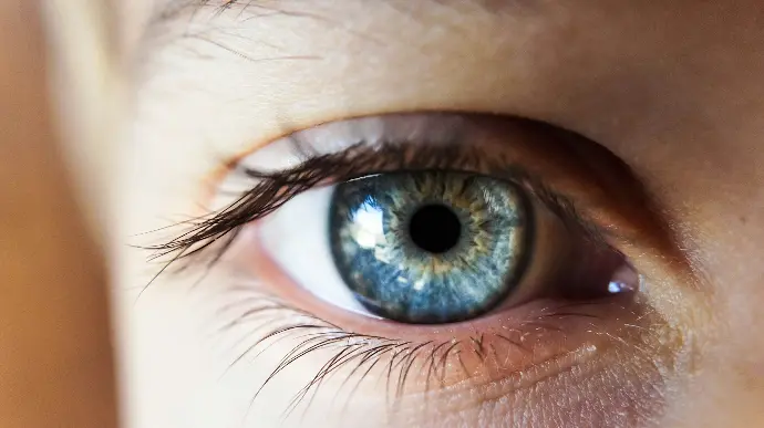 person opening his right eye with blue iris